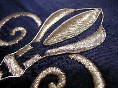 Satin Stitching with Metal Threads: Fleur-de-lis in silver thread on blue silk ground