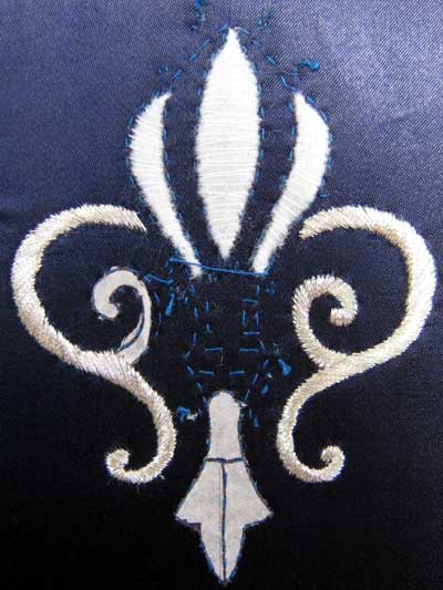 Satin Stitching with Metal Threads: Fleur-de-lis in silver thread on blue silk ground