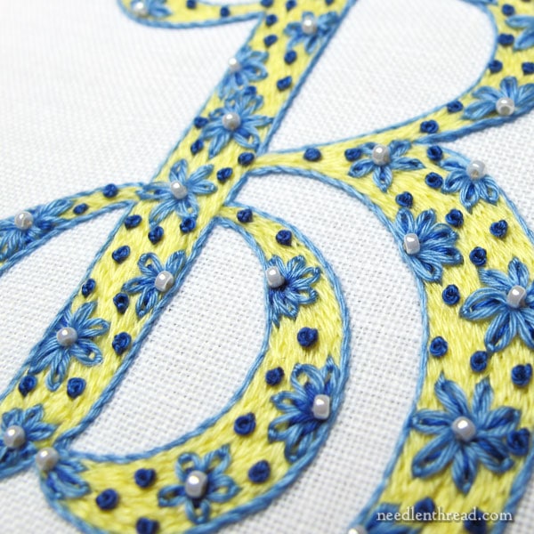 Yellow, blue and white monogram in hand embroidery