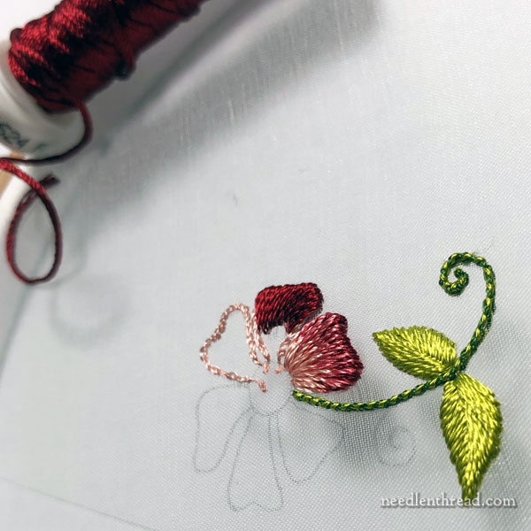 embroidered snowflake-like doodle in red